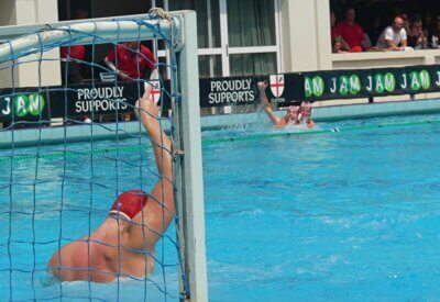 Clifton goalkeeper Ross Strauss raises a finger in triumph after pulling off the match-winning save after a penalty shootout against Paul Ross to claim third place. In the background, his team-mates, Ollie Ditz and Luc O'Brien celebrate.